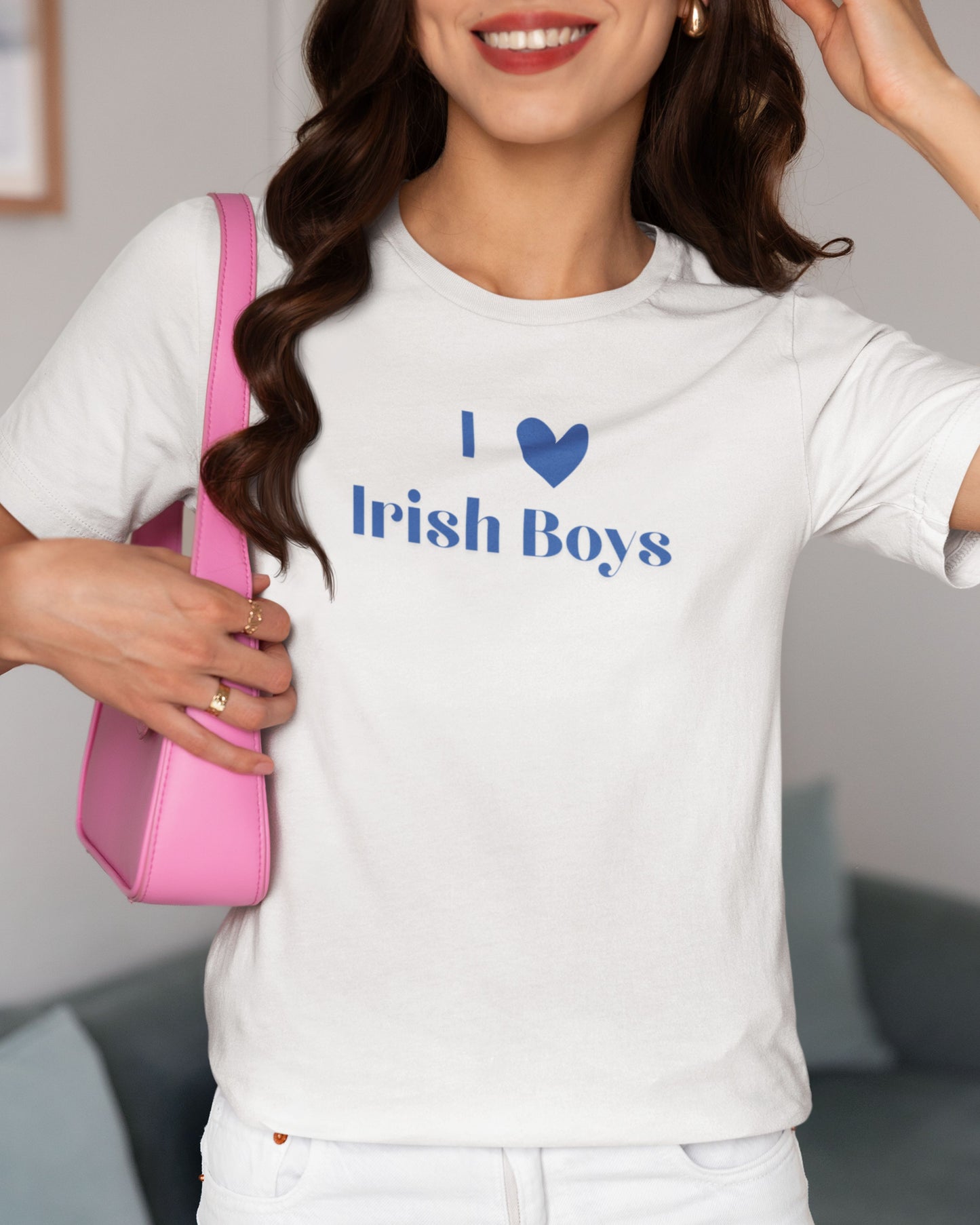 Cute girl wearing a white shirt that says I Heart Irish Boys. She is pairing this St. Paddys Day inspired shirt with a pink purse and gold jewlery.