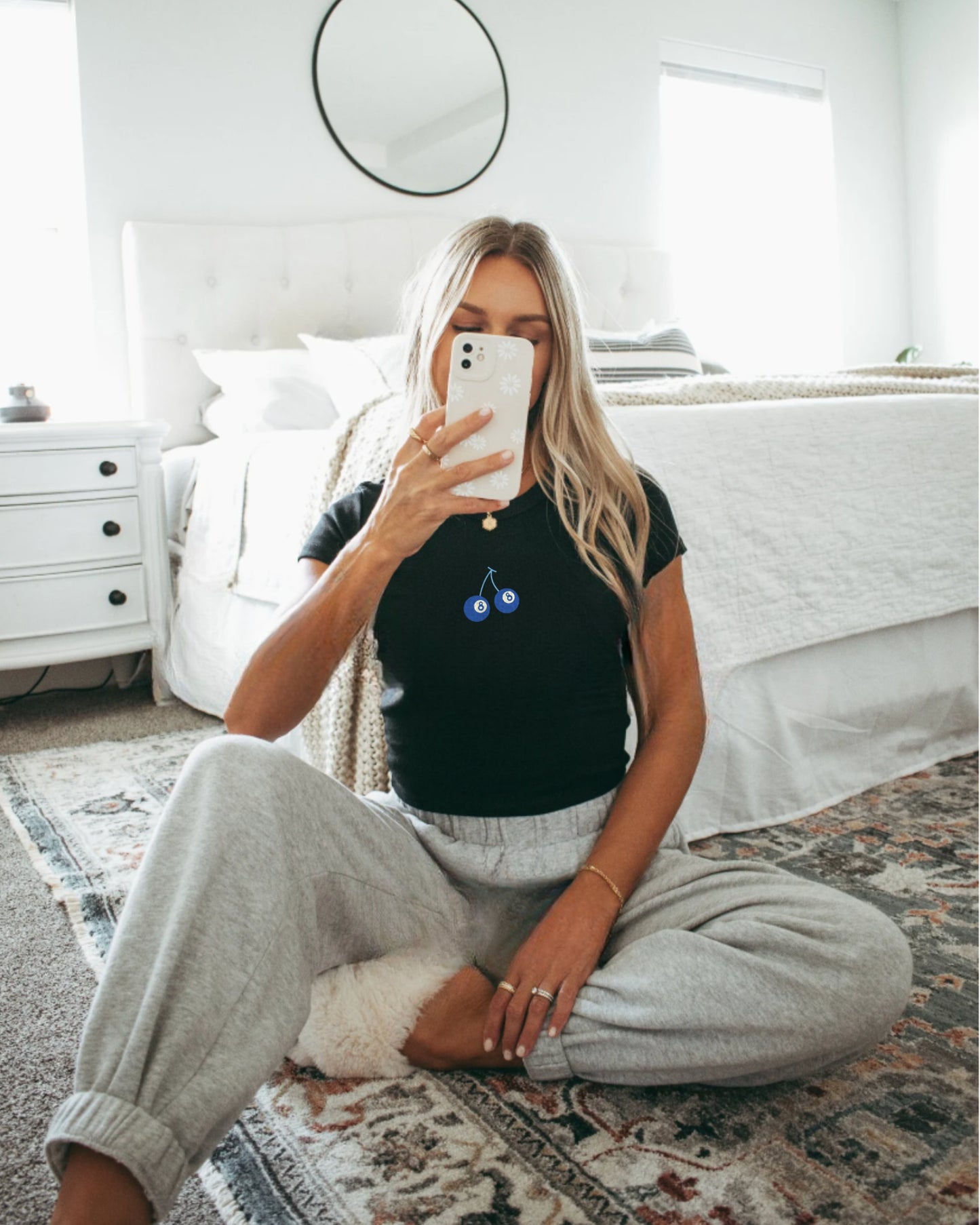 Girl in black eight ball cherry baby tee taking a mirror selfie.