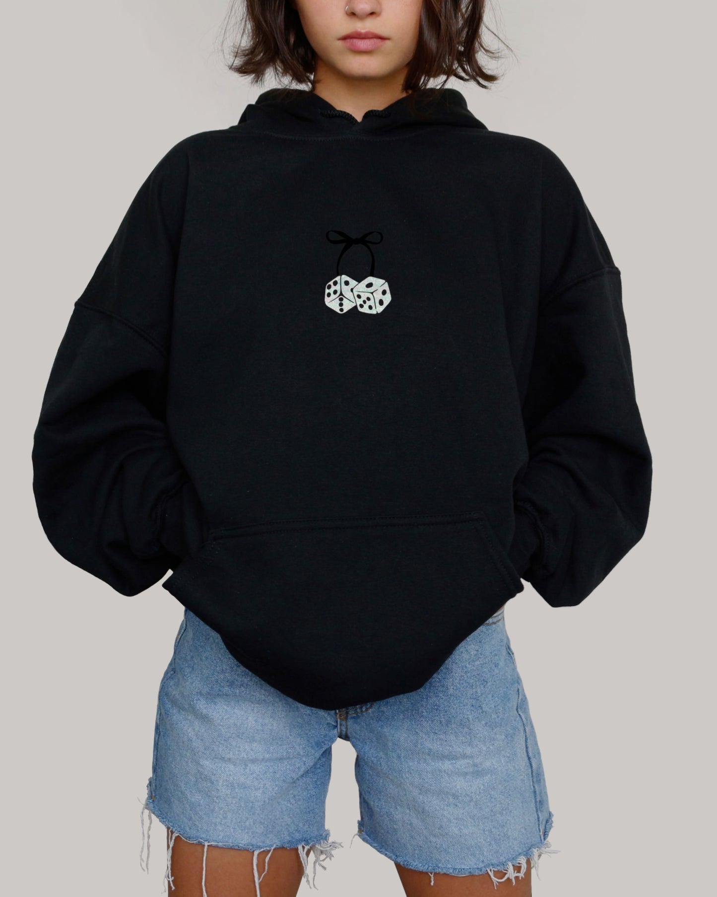 Girl wearing black hoodie featuring dice connected to a cute bow.