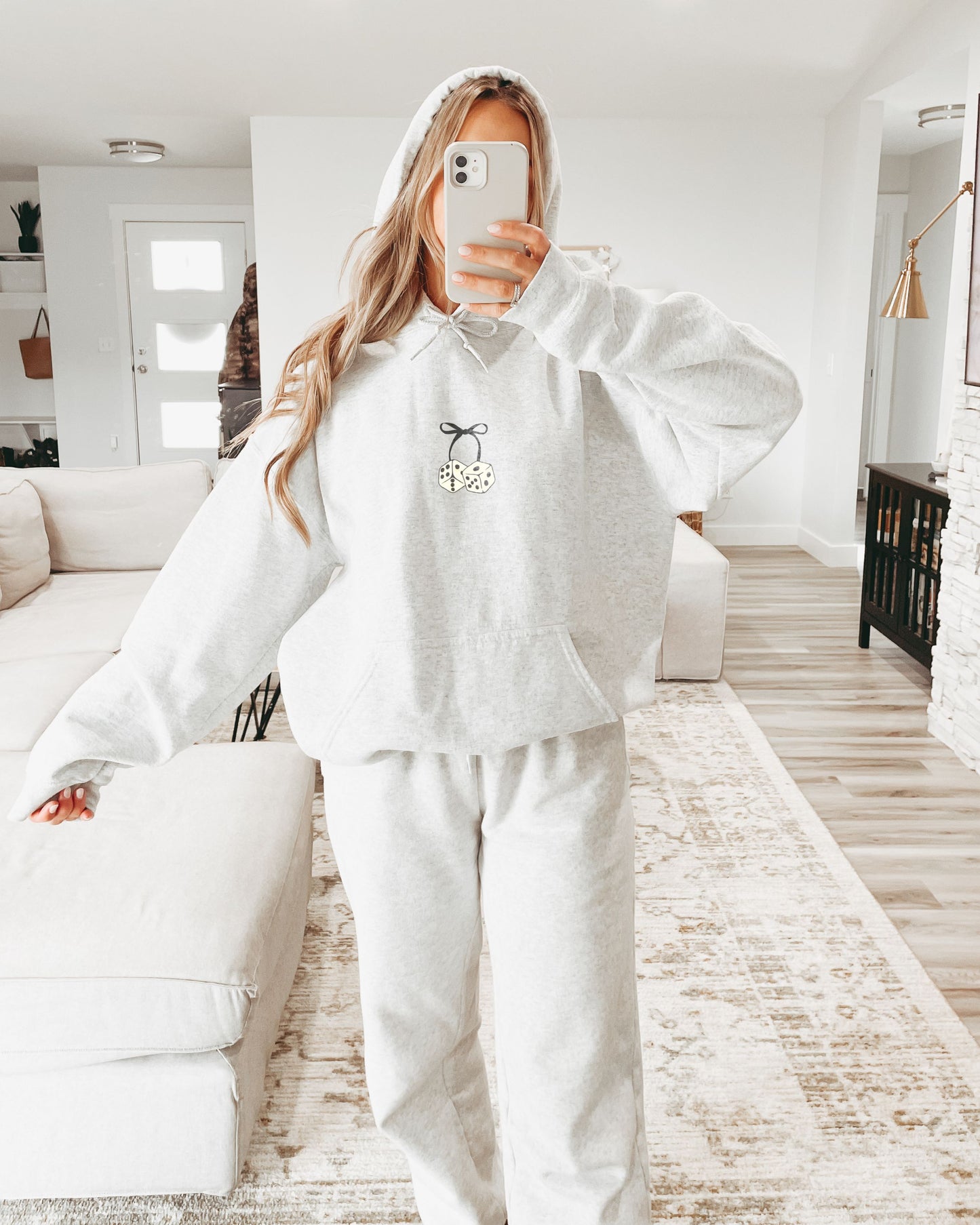Girl in cozy Feeling Lucky Dice and Bow Grey hoodie.