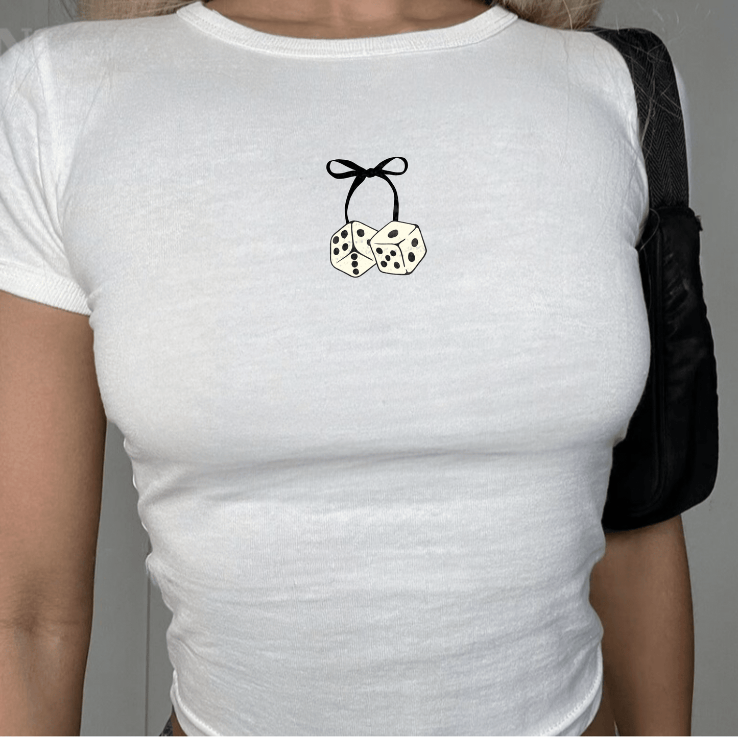 Close up image of a model wearing the Bow & Dice white baby tee