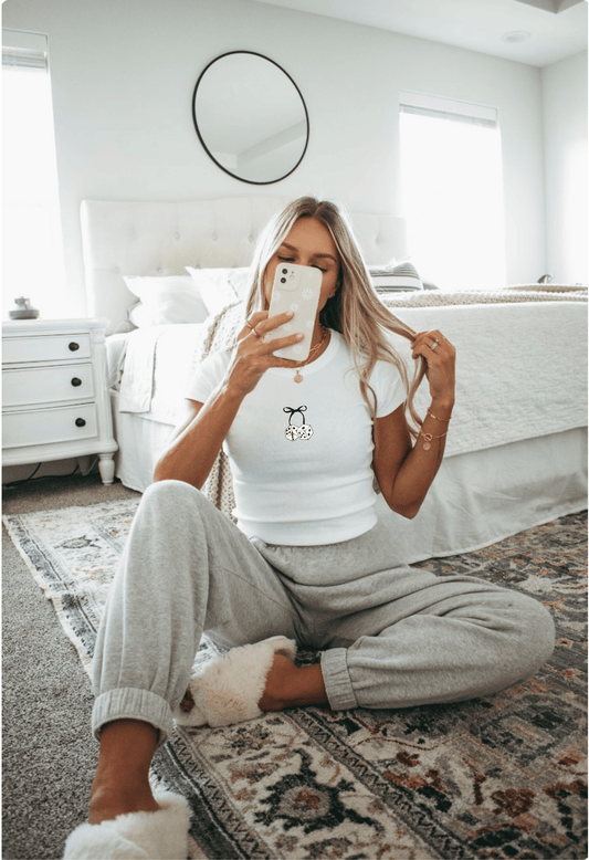 Girl in mirror selfie wearing Bow & Dice white baby tee crop top shirt.