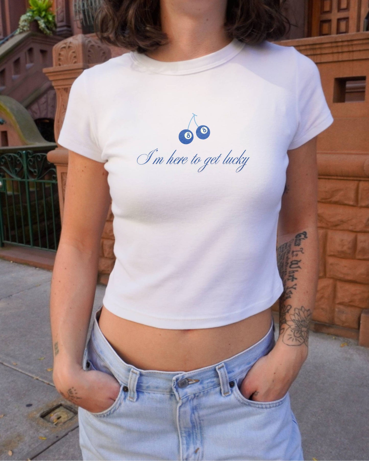 Girl outside wearing Im Here to Get Lucky baby tee by Lucky Days 